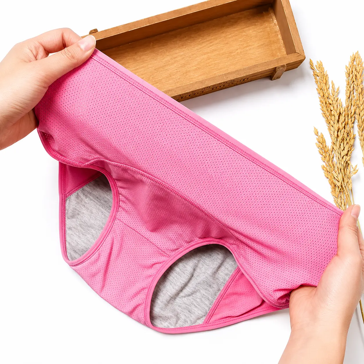 Hands stretching the waistband of DryGuard leak-proof underwear to show the fit